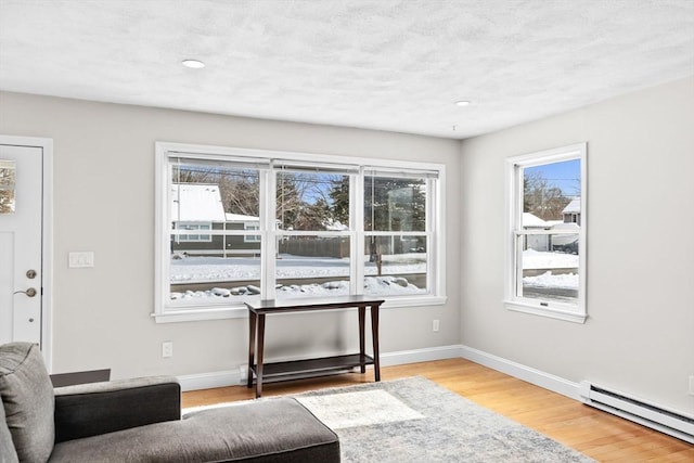 unfurnished room with a baseboard heating unit and hardwood / wood-style flooring