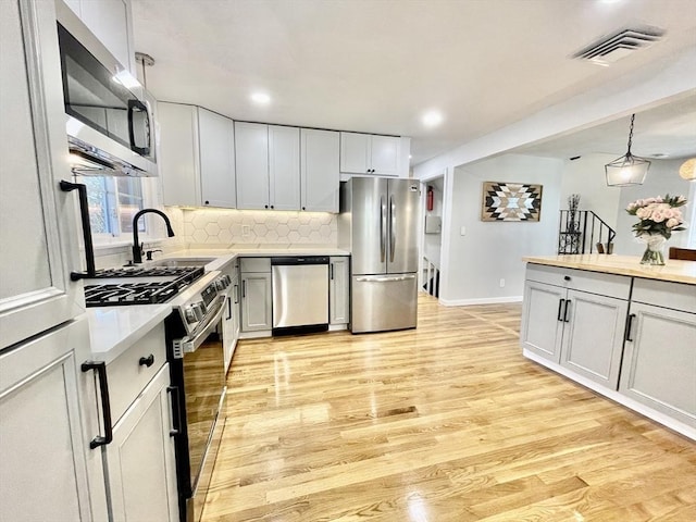 17 Brentwood Rd, Sudbury, MA 01776 - kitchen featuring tasteful backsplash, visible vents, appliances with stainless steel finishes, light countertops, and a sink