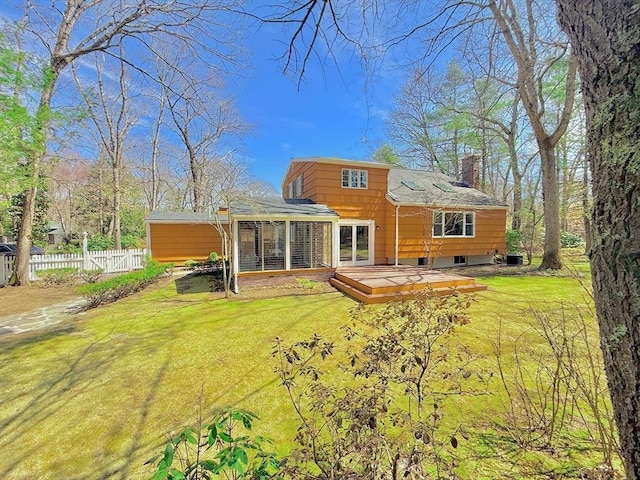 17 Brentwood Rd, Sudbury, MA 01776 - rear view of house featuring a deck, a chimney, fence, and a yard