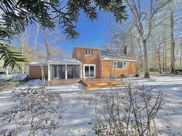 17 Brentwood Rd, Sudbury, MA 01776 - snow covered rear of property featuring fence, a wooden deck, and a chimney