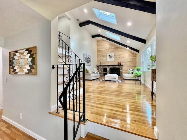 17 Brentwood Rd, Sudbury, MA 01776 - staircase featuring baseboards, a brick fireplace, beam ceiling, wood finished floors, and a skylight