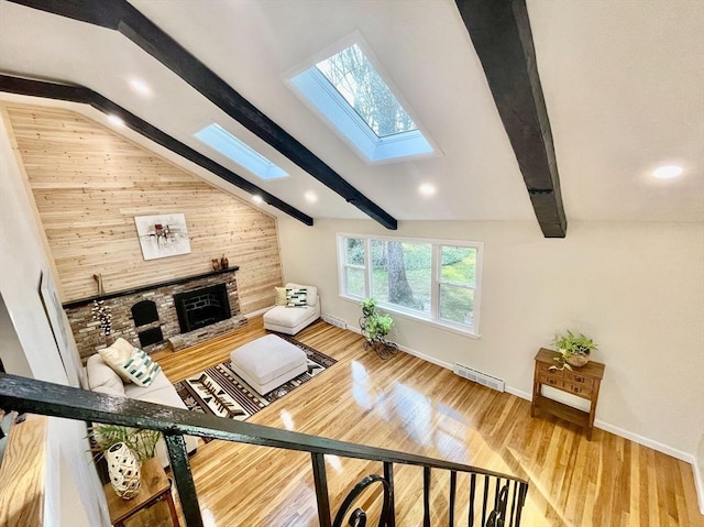 17 Brentwood Rd, Sudbury, MA 01776 - living room featuring visible vents, baseboards, a fireplace with raised hearth, lofted ceiling with skylight, and wood finished floors