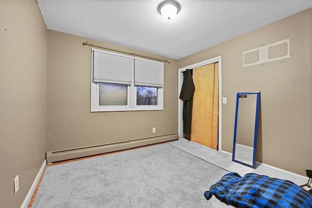 unfurnished bedroom featuring carpet flooring, a textured ceiling, a baseboard radiator, and a closet