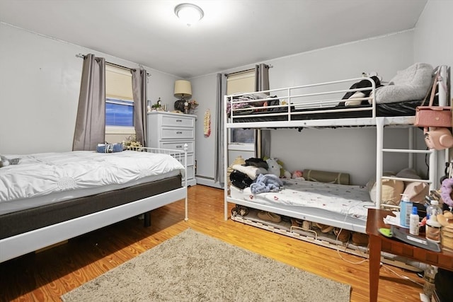 bedroom featuring hardwood / wood-style floors and a baseboard radiator