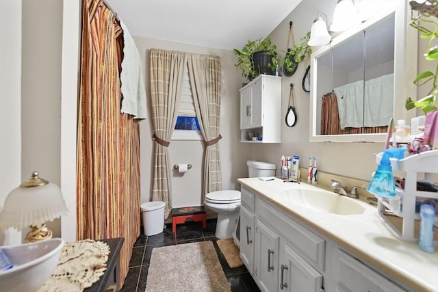 bathroom with tile patterned flooring, vanity, and toilet