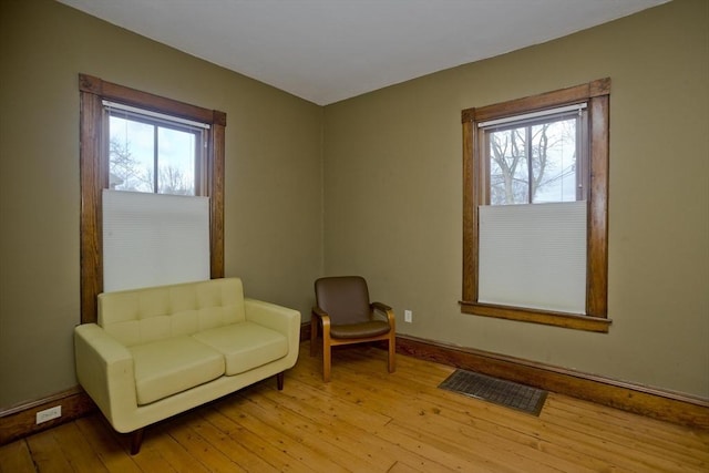 living area with a healthy amount of sunlight and light hardwood / wood-style floors