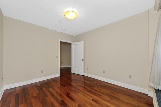 unfurnished room featuring baseboards and wood finished floors