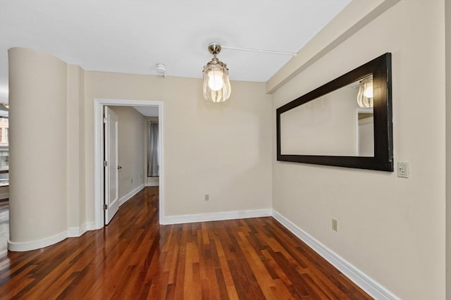 spare room featuring wood finished floors and baseboards