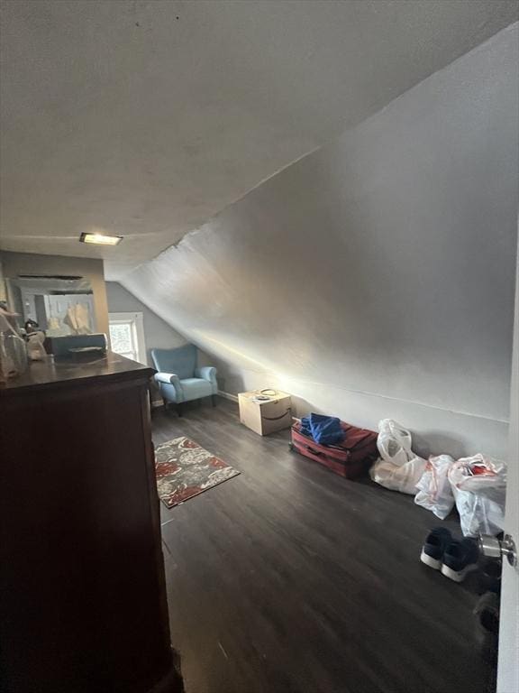 bonus room with dark hardwood / wood-style flooring and lofted ceiling