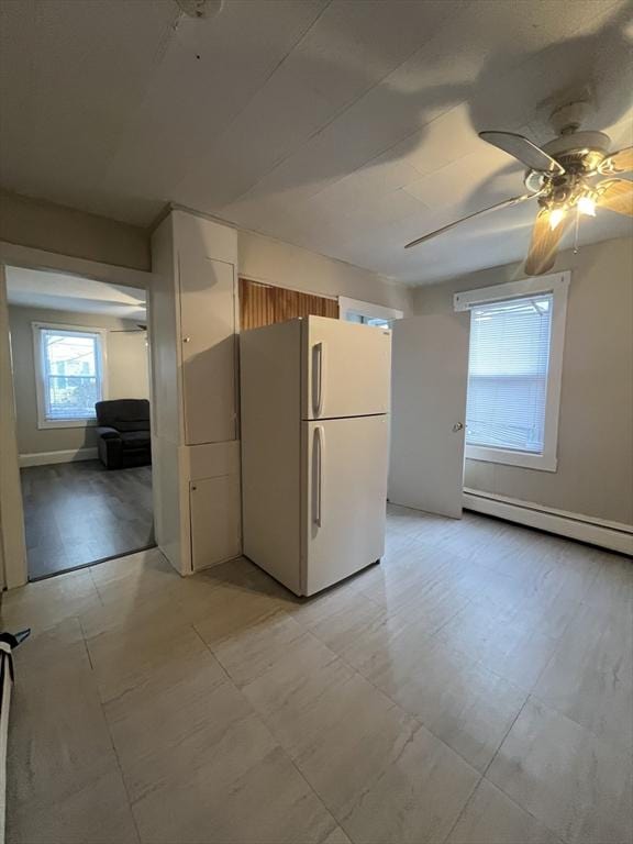 kitchen with white refrigerator, baseboard heating, and ceiling fan