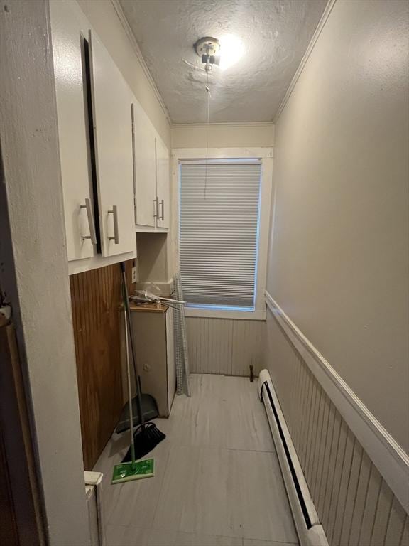 washroom featuring a textured ceiling, wooden walls, and crown molding