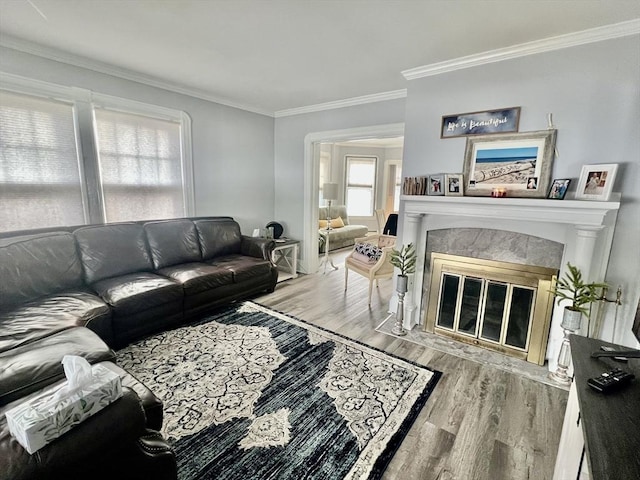 living area with crown molding, wood finished floors, and a tile fireplace