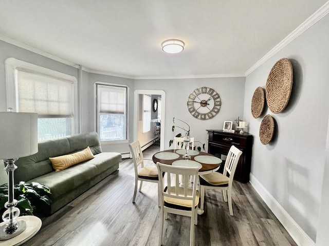 dining room with crown molding, baseboards, and wood finished floors