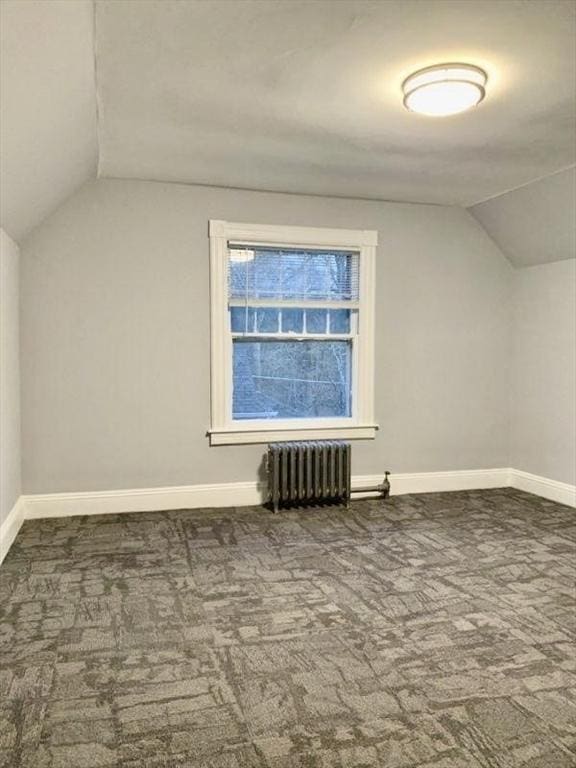 bonus room featuring carpet, baseboards, vaulted ceiling, and radiator heating unit