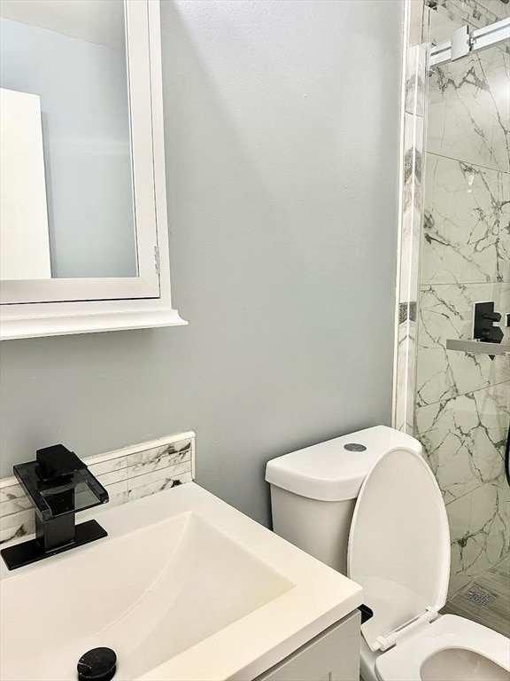 bathroom featuring vanity, toilet, and an enclosed shower