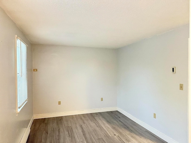 unfurnished room with a textured ceiling and hardwood / wood-style floors