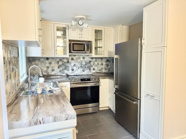 kitchen featuring appliances with stainless steel finishes, backsplash, and sink