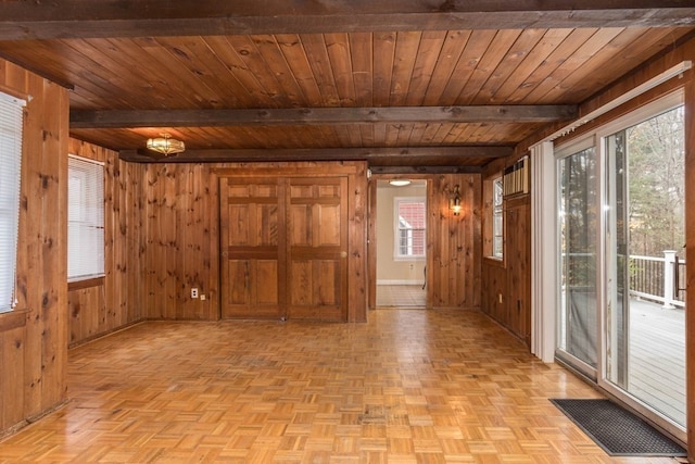 interior space with light parquet floors, wooden walls, wooden ceiling, and beam ceiling