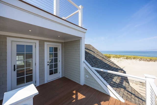 wooden deck featuring a view of the beach and a water view