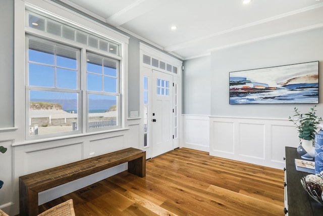 entrance foyer featuring wood-type flooring, ornamental molding, and a water view