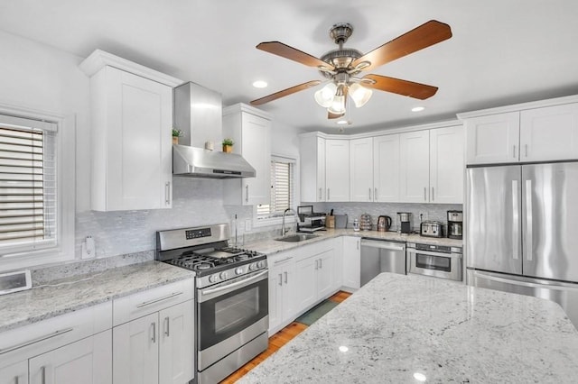 kitchen featuring sink, tasteful backsplash, light stone counters, appliances with stainless steel finishes, and white cabinets