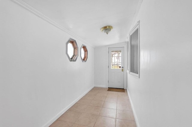 entryway featuring light tile patterned floors, crown molding, and lofted ceiling