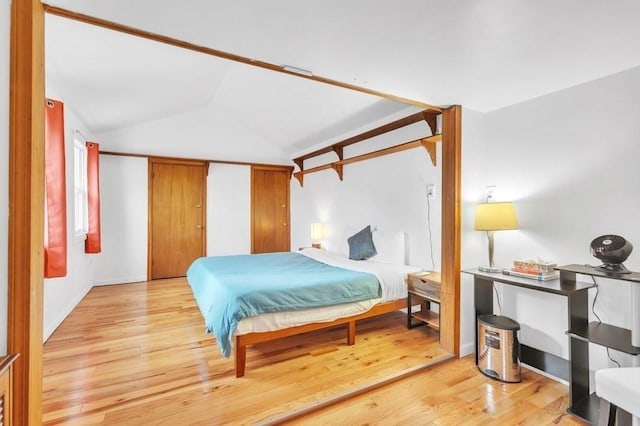 bedroom featuring light hardwood / wood-style floors and vaulted ceiling