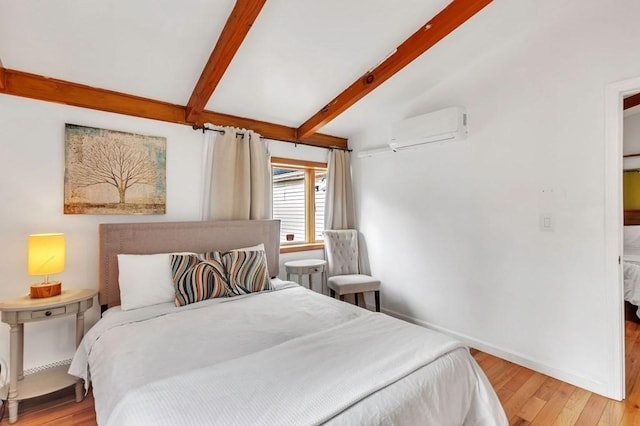 bedroom with a wall unit AC, light hardwood / wood-style floors, and beam ceiling