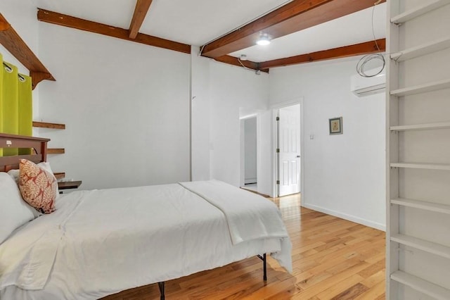 bedroom with light wood-type flooring, a wall mounted air conditioner, and lofted ceiling with beams