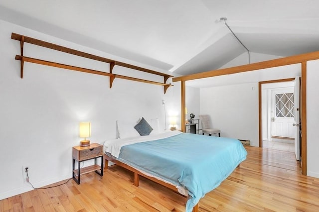 bedroom featuring light wood-type flooring and lofted ceiling