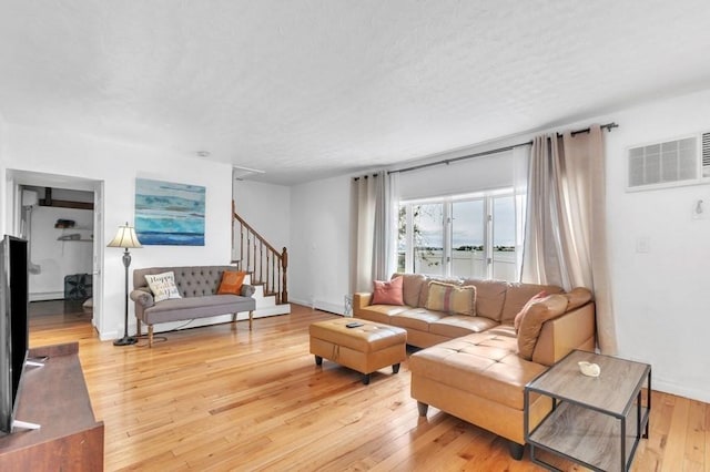 living room with a textured ceiling and light hardwood / wood-style floors