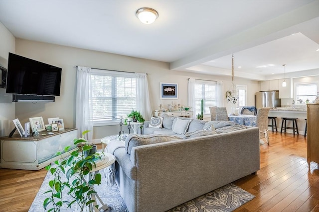 637 Gifford St Unit 4A, Falmouth, MA 02540 - living area with healthy amount of natural light, wood finished floors, and a tray ceiling