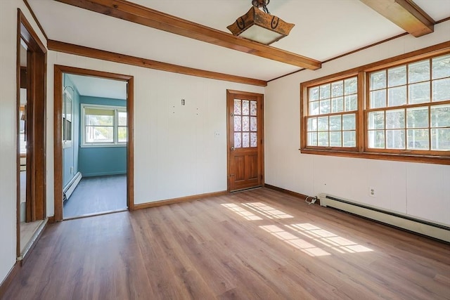 empty room featuring wood finished floors, baseboards, beam ceiling, and baseboard heating