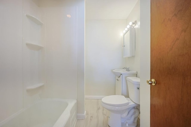 full bathroom featuring toilet, baseboards, a sink, and wood finished floors