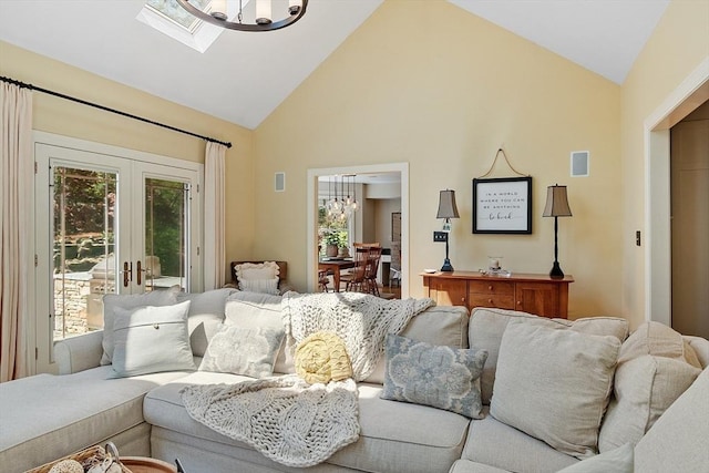 living room with french doors, high vaulted ceiling, an inviting chandelier, and a healthy amount of sunlight