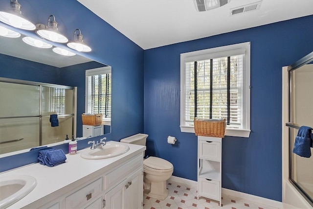 bathroom featuring an enclosed shower, baseboards, visible vents, and a sink