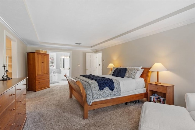 bedroom featuring visible vents, crown molding, light carpet, ensuite bathroom, and a tray ceiling