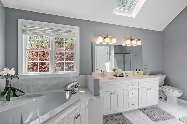 bathroom featuring a garden tub, double vanity, toilet, tile patterned floors, and a sink