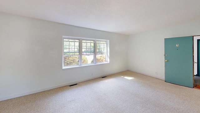 unfurnished room with visible vents, baseboards, and carpet