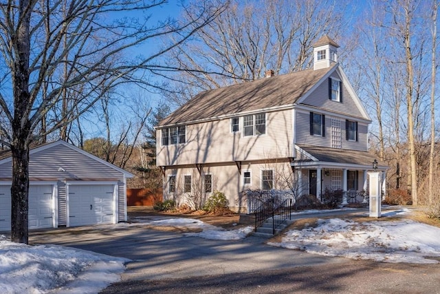 view of front of property featuring a garage, an outdoor structure, and a chimney