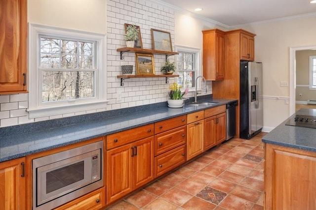 kitchen featuring a sink, backsplash, appliances with stainless steel finishes, and ornamental molding