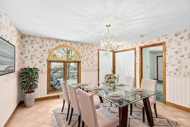 tiled dining room with an inviting chandelier