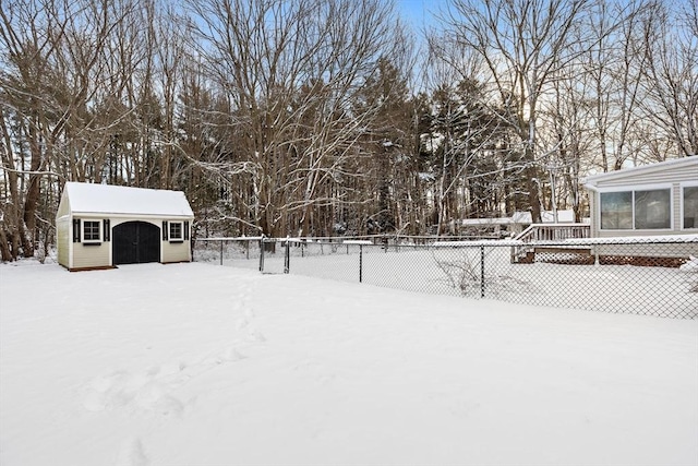 yard covered in snow featuring a storage shed