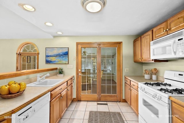 kitchen with sink, white appliances, and light tile patterned flooring