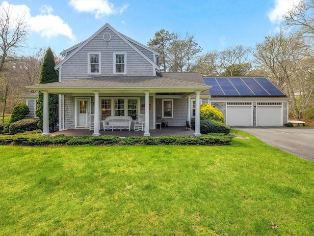 shingle-style home featuring a porch, a front lawn, asphalt driveway, and an attached garage