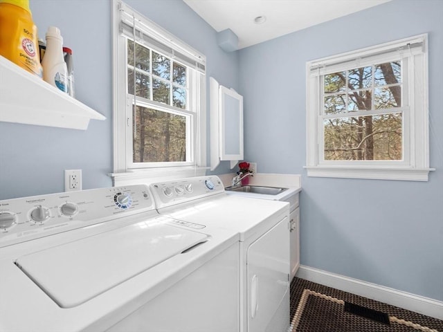 laundry room with cabinet space, washer and dryer, plenty of natural light, and baseboards