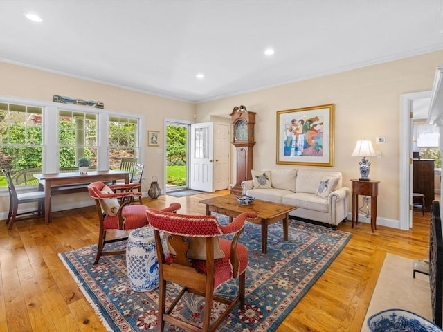 living room featuring crown molding, light wood-style flooring, recessed lighting, and baseboards
