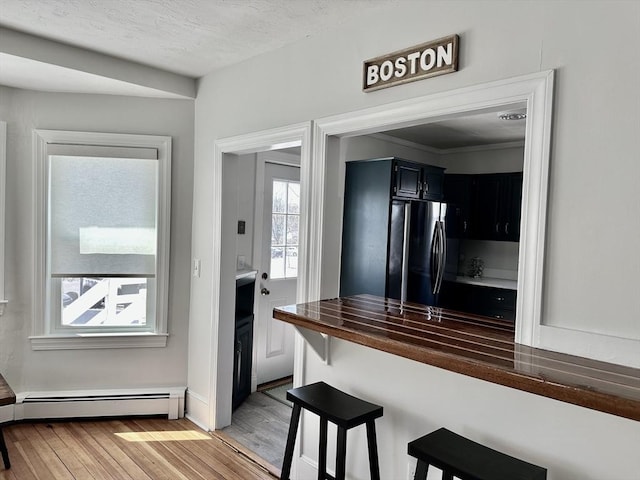 1 S Ave Unit 1, Hull, MA 02045 - kitchen with freestanding refrigerator, baseboard heating, light wood-type flooring, wooden counters, and a kitchen breakfast bar
