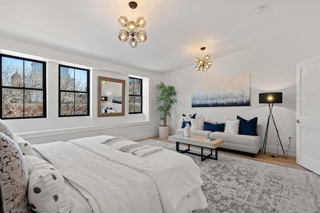 bedroom with an inviting chandelier, hardwood / wood-style flooring, and multiple windows