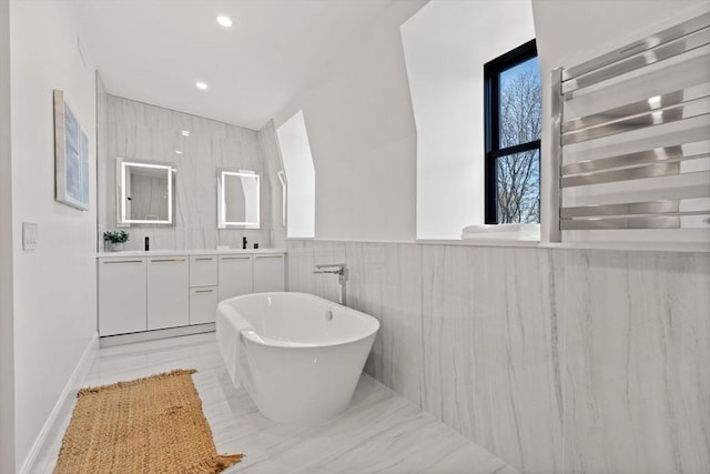 bathroom featuring vanity, radiator heating unit, a bathtub, and tile walls